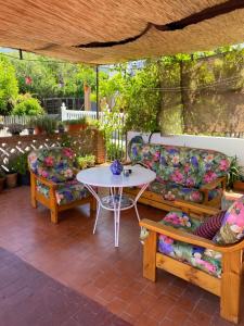 un patio con mesa, 2 sillas y sofá en Casita Rural La Rosa de la Huerta con chimenea interior en Monachil