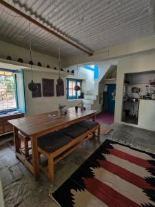 ein Esszimmer mit einem Holztisch und Bänken in der Unterkunft Turiya niwas Kasar Devi in Almora