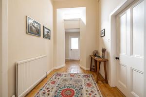 a hallway with a door and a rug at Lower Tweedknowe - ground floor villa Melrose in Melrose