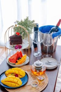 a table topped with plates of fruit and wine glasses at Nontawa Villa & Cafe in Ban Huai Khai