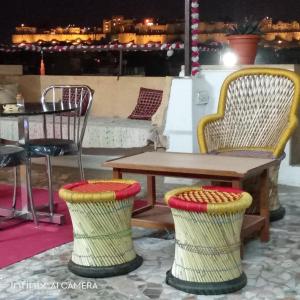 ein Tisch und zwei Stühle sowie ein Holztisch und -tische in der Unterkunft Hotel Abhinav Jaisalmer in Jaisalmer