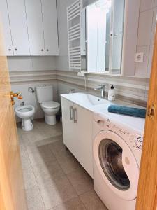 ein Badezimmer mit einer Waschmaschine und einem WC in der Unterkunft Piso en playa de Alicante in Alicante