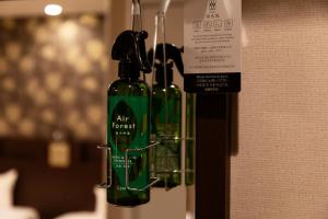 a green bottle of wine hanging from a wall at Hotel. Links Namba in Osaka