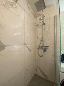 een badkamer met een douche en een glazen deur bij Appartement - Nanterre in Nanterre