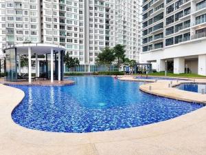 a large blue swimming pool in front of tall buildings at Bora Residences by Antlerzone in Johor Bahru