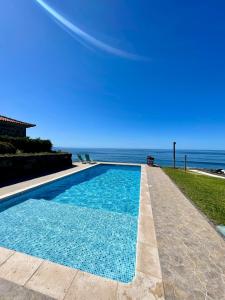 a swimming pool with a view of the ocean at Casa do mar in São Vicente