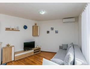a living room with a couch and a television at Apartments Vulić in Omiš