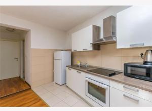 a kitchen with a white refrigerator and a microwave at Apartments Vulić in Omiš