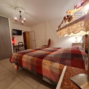 a bedroom with a bed with a checked blanket at Impérial in Puy-lʼÉvêque