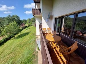 a patio with a table and chairs on a balcony at Emmy - Breathtaking view, cosy apartment, Wi-fi, parking in Winterberg