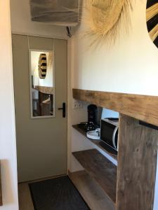 Una cocina con puerta de madera y microondas. en Au Dessus De Chez Nous, en Doulezon