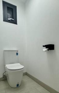 a bathroom with a toilet in a white wall at 1BR Apartment - Walk to City (1 Queen Bed) in Hobart