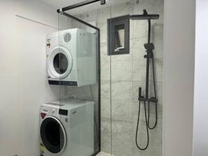 eine Waschmaschine und eine Waschmaschine im Bad in der Unterkunft 1BR Apartment - Walk to City (1 Queen Bed) in Hobart