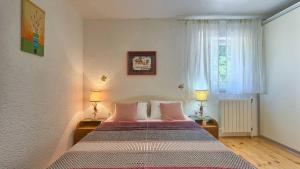 a bedroom with a bed with two lamps and a window at Villa Emma, a charming villa in an idyllic location ner the sea in Strmac +35 photos