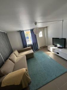 sala de estar con sofá y TV de pantalla plana en Lägenheter i Luleå en Luleå