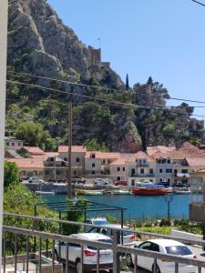 a group of cars parked in a parking lot with a mountain at Apartment Navika in Omiš