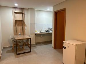ein kleines Zimmer mit einem Tisch und einer kleinen Küche in der Unterkunft Loft Solaris Apart Hotel - Suíte - Apt N102 in João Câmara