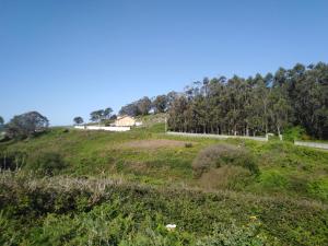 een grasheuvel met een huis erop bij 3 bedroom house near beach lighthouse hiking trail in Corme-Puerto