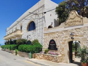 a building with a sign on the side of it at Cornucopia Hotel in Xagħra