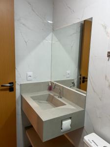 ein Bad mit einem Waschbecken und einem Spiegel in der Unterkunft Loft Solaris Apart Hotel - Suíte - Apt N102 in João Câmara