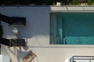 an overhead view of a swimming pool with two chairs at Experience Penthouse by Athens Riviera Suites in Saronida