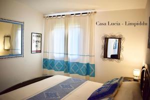 ブドーニにあるCasa Luciaのベッドルーム1室(ベッド1台、鏡、窓付)