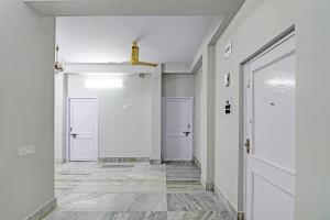 un pasillo con paredes blancas y 2 puertas en OYO Flagship The Image A Quality Stay en Calcuta