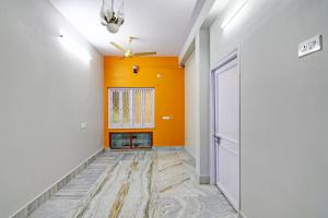 un pasillo vacío con una pared naranja y una puerta en OYO Flagship The Image A Quality Stay en Calcuta