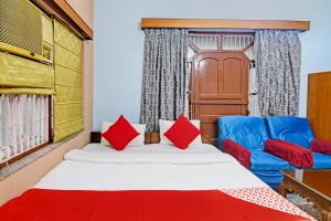 1 dormitorio con 1 cama y 2 sillas azules en OYO Flagship The Image A Quality Stay en Calcuta
