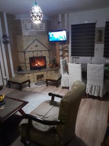 Apartmani Lale i Rada : غرفة معيشة مع كرسي ومدفأة