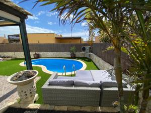 un cortile con divano e piscina di Casa Rosalía a Corralejo