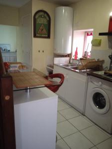 een keuken met een wastafel en een wasmachine bij Chez Fa et Pascal in Lanester