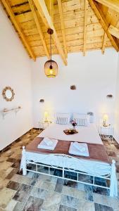 een slaapkamer met een groot bed in een kamer met houten plafonds bij Cassiopea Guest House Evia Greece in Nerotriviá