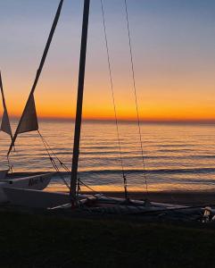 a sail boat on the beach at sunset at Joma Adventure Lodge in Senga