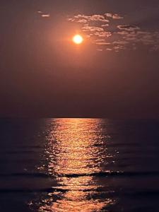 um pôr-do-sol sobre o oceano com o sol no céu em Joma Adventure Lodge em Senga