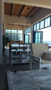 uma sala de estar com uma mesa, cadeiras e janelas em Joma Adventure Lodge em Senga