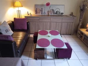 een woonkamer met een tafel en een bank bij Chez Fa et Pascal in Lanester