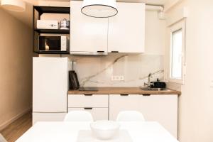 Una cocina blanca con gabinetes blancos y un fregadero. en Piso Muralla Romana, en León 10 fotos más