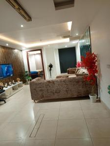 Il comprend un grand salon avec un canapé et une télévision. dans l'établissement Luxury rooms studioLahore, à Lahore