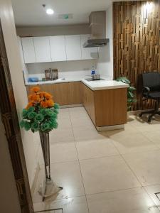 Luxury rooms studioLahore في لاهور: مطبخ مع مزهرية مع زهور برتقالية فيه