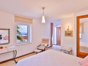 a bedroom with a bed and a chair and a window at VILLA SCARLETT in Kaş +17 photos