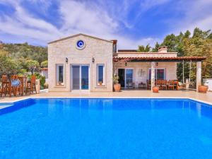 a large blue swimming pool in front of a house at VILLA SCARLETT in Kaş