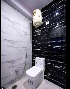 a bathroom with a white toilet and a black wall at House Of Touristers Hotel & Cafe in Jaipur