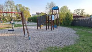 a park with a playground with two swings at Crow's nest in Grobiņa