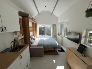 een slaapkamer met een bed en een keuken met een wastafel bij Tiny Home in Aalsmeer