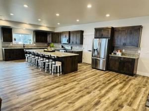 a large kitchen with wooden floors and a refrigerator at Pickleball Paradise at Star Valley Ranch! in Thayne