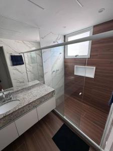 y baño con ducha y lavamanos. en Cobertura linear, 3 quartos, Peninsula (Barra da tijuca), en Río de Janeiro