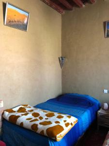 1 dormitorio con 1 cama con edredón marrón y blanco en GITE LA GROTTE VALLEE 