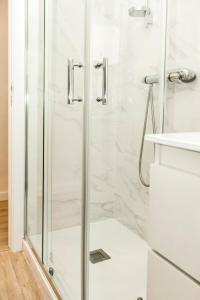 una ducha con puerta de cristal en un baño en Piso Muralla Romana, en León