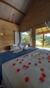 um quarto com uma cama com pétalas de rosa vermelhas em REFUGIO PIEMONTE Chalés em Socorro